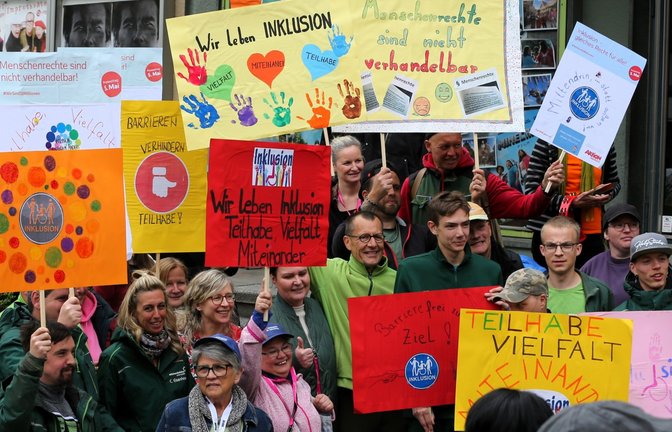 Betroffene machen mit bunten Plakaten auf die Belange von Menschen mit Behinderung aufmerksam.