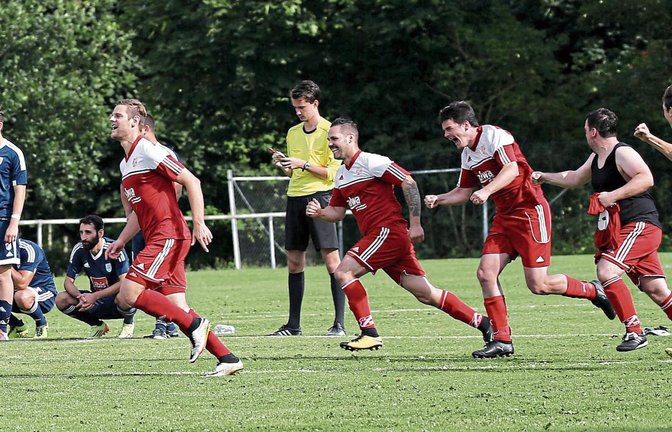Der letzte Elfmeter ist verwandelt, die SGM Hohenhaslach/Freudental wieder in der A-Klasse angekommen. Die Mannschaft stürmt jubelnd los, die Hellas-Kicker (in Blau) steigen ab. Fotos: Küppers