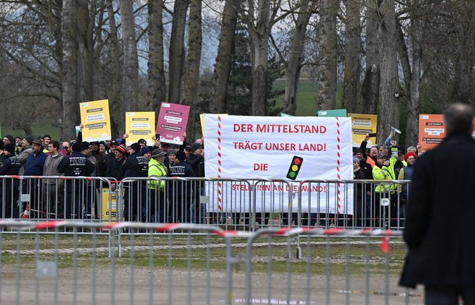 Mehrere hundert Meter trennt die Landwirte vom Bundeskanzler. Hinter den Absperrgittern macht die protestierende Menge ihrem Ärger Luft.<span class='image-autor'>Foto: dpa/Bernd Weißbrod</span>