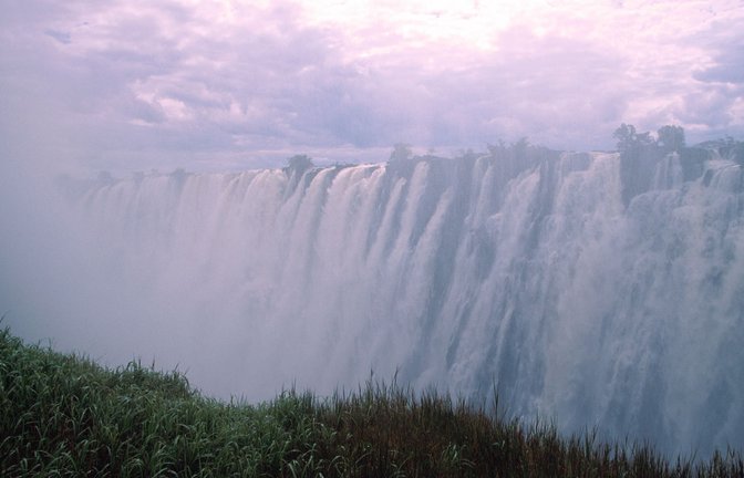 Die Victoriafälle am Sambesi zwischen den Grenzstädten Victoria Falls in Simbabwe und Livingstone in Sambia: Zum Ende der Regenzeit im Februar und März schießen bis zu 10 000 Kubikmeter Wasser pro Sekunde über den Nordrand der Schlucht in die Tiefe.<span class='image-autor'>Foto: Imago/Pond5 Images</span>