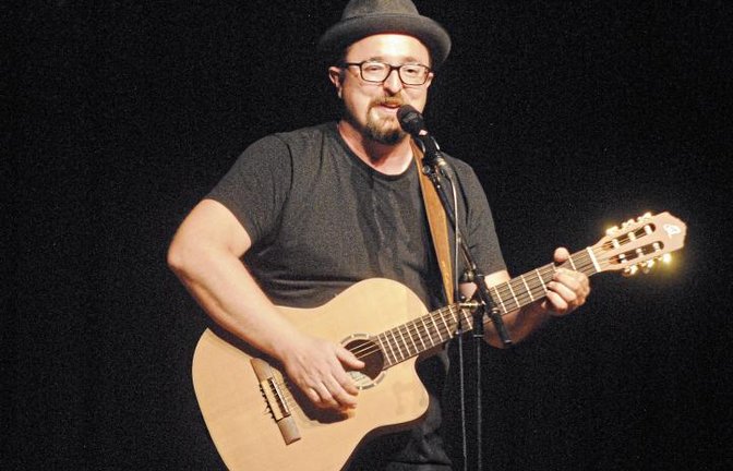 Mit Gitarre und Ziehharmonika sorgt Helmut A. Binser für Unterhaltung.  Foto: Stahlfeld