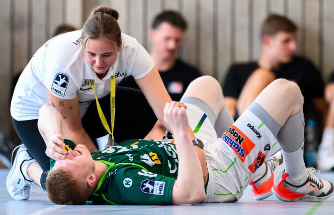 Kapitän Ymir Gislason wird von Frisch-Auf-Physiotherapeutin Katharina Leßig beim Turnier in Altensteig versorgt&nbsp;– seine Verletzung an der Wurfhand zog sich der Isländer im Bundesligaspiel bei der MT Melsungen zu.<span class='image-autor'>IMAGO/wolf-sportfoto</span>