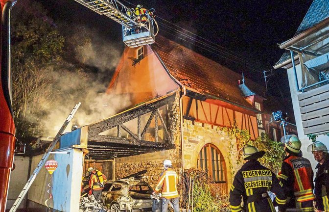 Die Einsatzkräfte der Feuerwehren Oberriexingen, Sersheim, Sachsenheim und Vaihingen verhindern, dass das Feuer auf das angrenzende Gebäude übergreift.  Foto: SDMG/Haslinger