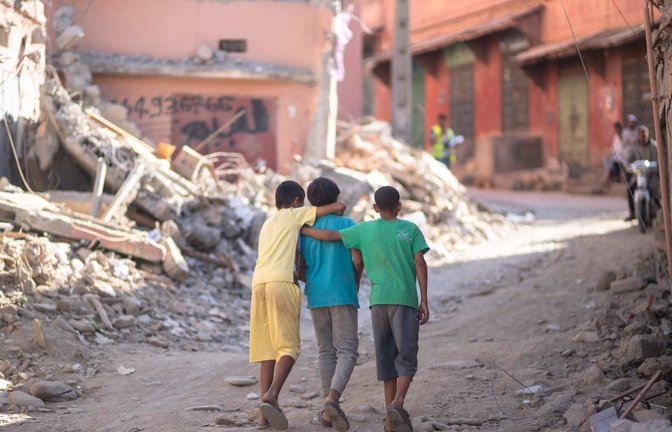 Drei Kinder laufen durch die Trümmer der Stadt Amizmiz außerhalb von Marrakesch und spenden sich gegenseitig Trost. Bald eine Woche nach dem Jahrhundert-Erdbeben in Marokko fehlt es für unzählige Menschen immer noch am Nötigsten. Die Zahl der bestätigten Todesfälle ist auf knapp 3000 gestiegen.<span class='image-autor'>Foto: Mosa'ab Elshamy/AP/dpa</span>