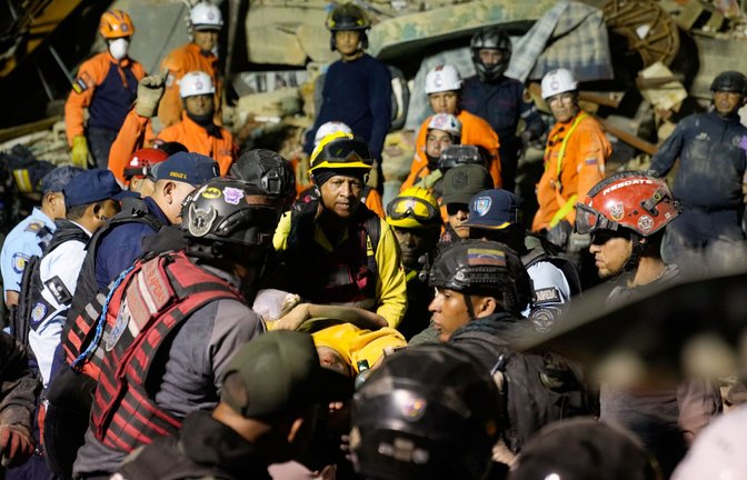 Rettungskräfte durchsuchen nach einem Erdbeben in den Trümmer eines eingestürzten Gebäudes.<span class='image-autor'>Foto: Ariana Cubillos/AP/dpa/Ariana Cubillos</span>