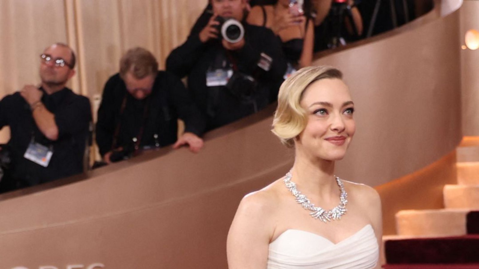 So geht Glamour: Amanda Seyfried entschied sich für ein weißes Off-Shoulderkleid von Versace. Very „Old Hollywood“: Die Wasserwelle im Haar.Foto: AFP