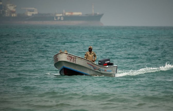 Vor dem Hintergrund eines LPG-Tankers (Flüssiggas) fährt ein jemenitischer Soldat in den Gewässern nördlich der Straße von Bab el-Mandeb. (Archivbild).<span class='image-autor'>Abdulnasser Alseddik/AP/dpa</span>