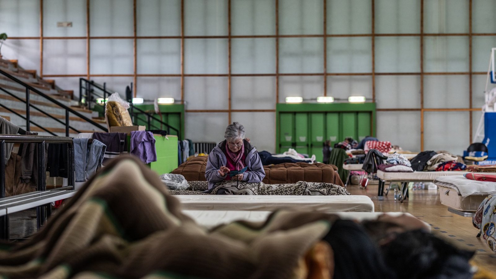 Castel Bolognese: Eine ältere Frau sitzt auf einem Bett in einer Turnhalle, die als Unterkunft für Flutopfer dient.Foto: Oliver Weiken/dpa Castel Bolognese: Eine ältere Frau sitzt auf einem Bett in einer Turnhalle, die als Unterkunft für Flutopfer dient.Foto: Oliver Weiken/dpa