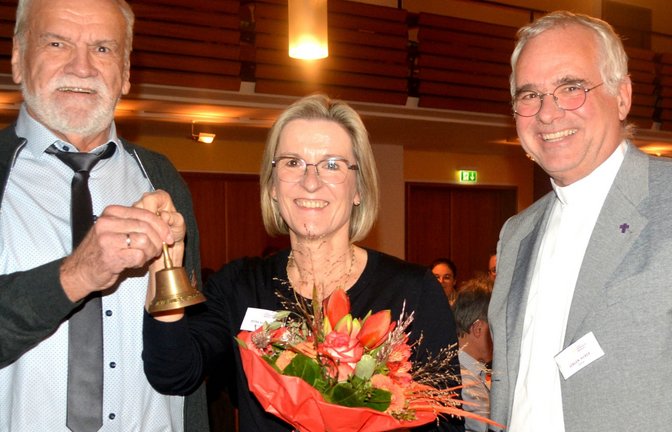 Dekan Jürgen Huber (rechts) würdigt die Verdienste von Bernd Dingler, der die Sitzungsglocke des Vorsitzenden der Bezirkssynode an Petra Klisa weiterreicht. <span class='image-autor'>Foto: Stahlfeld</span>