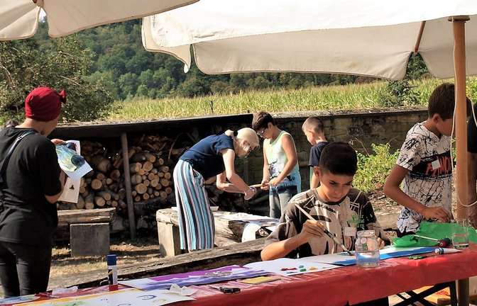 Der Pfarrgarten wird zum bunten Maleratelier. Betreut werden die Kinder von (von links): Pfarrerin Sigrid Telian, der Helferin Salematou, der Künstlerin Irene Tennigkeit und Helferin Ottilie Läkemäker.  <span class='image-autor'>Fotos: Filitz</span>