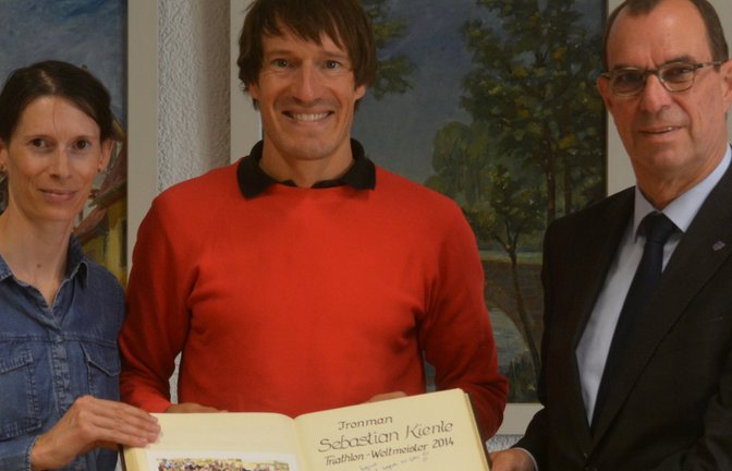 Eingerahmt von seiner Frau Christine Schleifer und OB Frank Schneider freut sich Sebastian Kienle über seinen Eintrag ins Goldene Buch der Stadt Mühlacker. <span class='image-autor'>Foto: Stahlfeld</span>
